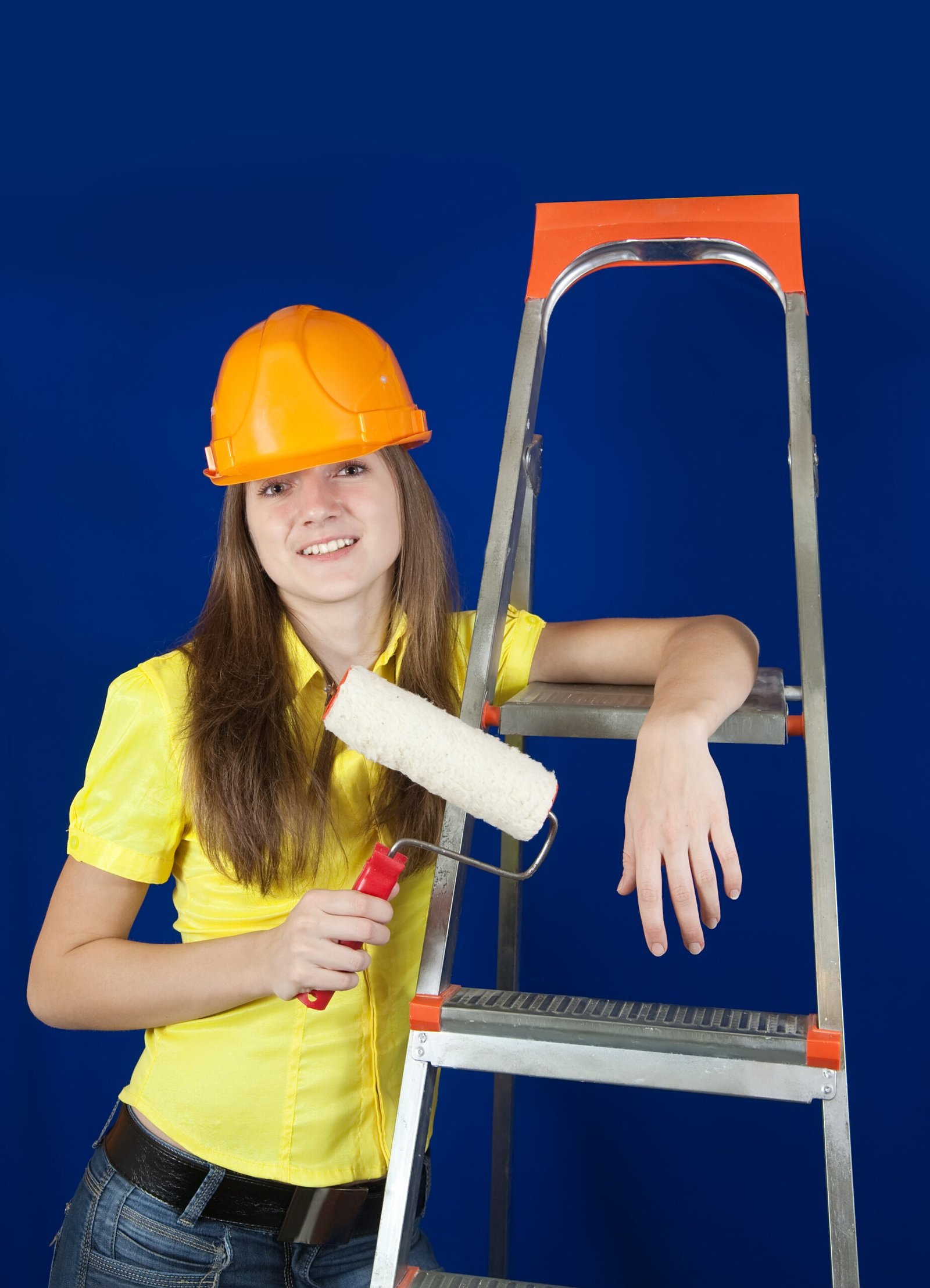female house painter with paint rollers near scaling-ladder